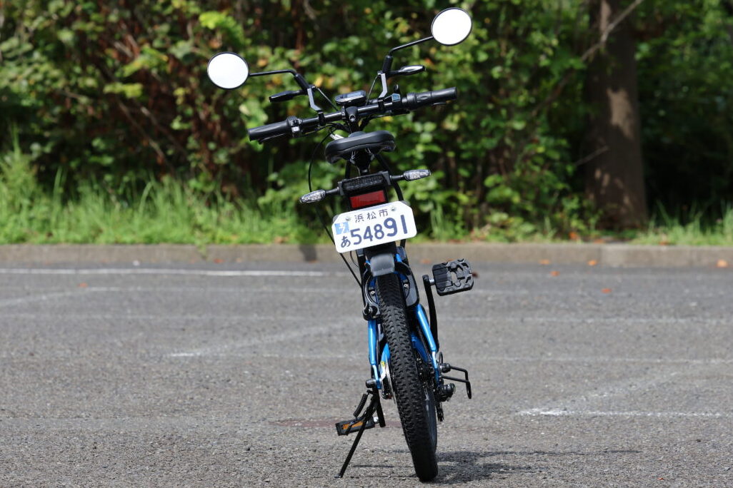 見た目は電動アシスト自転車に見えるが原付一種（～50cc）でナンバー付き。